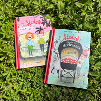 na zielonej trawie leżą dwie książki o przygodach Śledzika