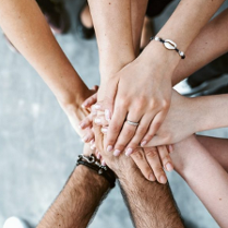 Ręce wielu osób, które nakładają się jedne na drugie.