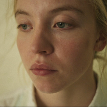 Zbliżenie na twarz młodej dziewczyny o jasnych włosach.