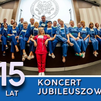 Grupa osób ubranych w niebieskie stroje lekarskie siedzi w rzędach, przed nimi jedna osoba w czerwonym stroju.