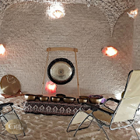 Zdjęcie wykonano we wnętrzu groty solnej. Przed leżakiem znajdującym się po prawem na podłodze znajdują sięe misy do gry, natomiast pod ścianą na wprost stoi gong.