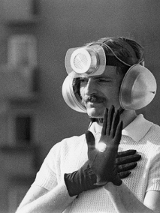 Mężczyzna w rękawiczkach, słuchawkach i głośnikiem na czole.