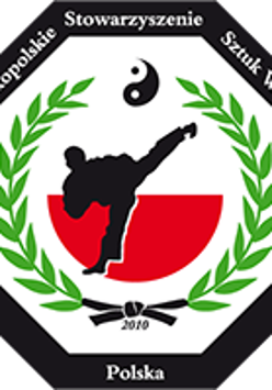 Logotyp Wielkopolskiego Stowarzyszenia Sztuk Walki - w środku na biało-czerwonym tle wizerunek kopającego zawodnika. Wokół jest liść laurowy oraz czarne obramowanie z nazwą organizacji