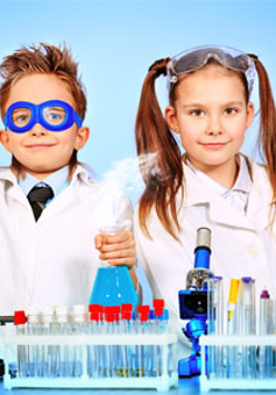 Mali naukowcy: chłopiec i dziewczynka w kitlach wykonują doświadczenia.