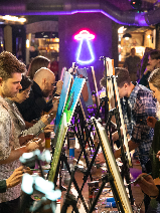 Grupa osób maluje obrazy na sztalugach.