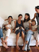 Siedzące na łóżku kobiety wraz ze swoimi dziećmi.