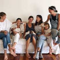 Siedzące na łóżku kobiety wraz ze swoimi dziećmi.