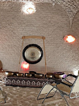 Gong na stojaku, misy na podwyższeniu na dywanie. Z przodu dwa leżaki.