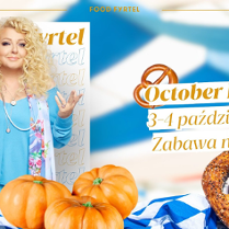 Na stole z biało-niebieskim obrusem w krate leżą przysmaki jak dynia, precle i piwo. W tle zdjęcie Magdy Gessler.