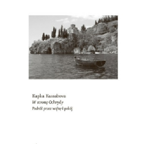 Łódka na spokojnym morzu w pobliżu urwiska. Na lądzie drzewa i skały.