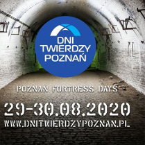 Fort od srodka. Ściany i sklepienie z cegeł. Na środku logo imprezy: białe litery na niebieskim tle.