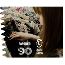 Kobieta przeglądająca ubrania na wieszakach.