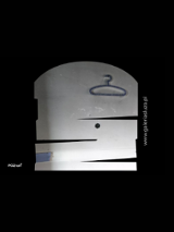 Fioletowy wieszak na szarej ścianie, wklejonej na czarne tło, obok informacje na temat wydarzenia- Galera Śluza, Przynęty i pułapki, Lures and traps, 15.05-04.07.2021 oraz sponsorzy.