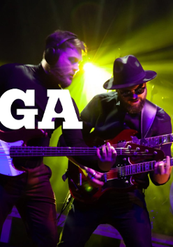 Dwóch muzyków grających na gitarach. Oświetla ich zielone światło.