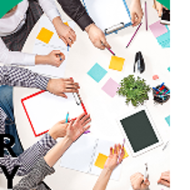 Grupa osób przy okrągłym stole. Na stole notatki, kolorowe karteczki, długopisy.