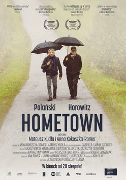 Ryszard Horowitz i reżyser Roman Polański idą ścieżką, w rękach trzymają paraslki.