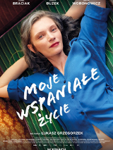 Plakat przedstawia kobietę w średnim wieku, która leży na zielonym materacu. Ma na sobie niebieską koszulę, która podwinęła się do góry odsłaniając jej pępek. Kobieta ma ręce założone za głowę i patrzy w obiektyw.