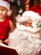 Mikołaj i 2 dzieci przeglądaja książkę.