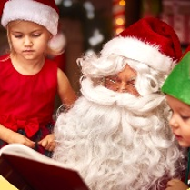 Mikołaj i 2 dzieci przeglądaja książkę.