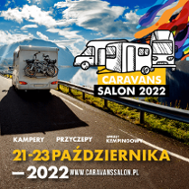 Kamper jadący drogą wśród górskich szczytów.