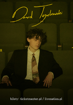 Zdjęcie artysty siedzącego w sali kinowej. Żołte napisy z informacjami o wydarzeniu.