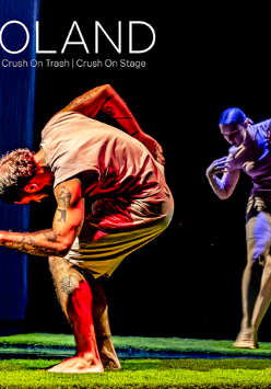 Na scenie na trawie tańczą dwie osoby, z przodu mężczyzna, w tle kobieta