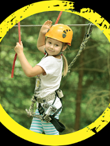 Dziewczynka w parku linowym, w asekuracyjnej uprzęży.