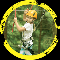 Dziewczynka w parku linowym, w asekuracyjnej uprzęży.