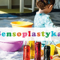 Napis sensoplastyka, za nim dziecko stojące wśród misek.
