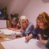 Grupa osób podczas zajęć plastycznych.