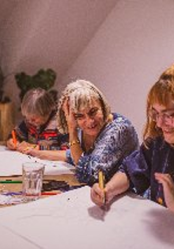 Grupa osób podczas zajęć plastycznych.