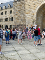 Grupa ludzi stoi pod wejściem do Kina Pałacowego w poznańskim Zamku Cesarskim.