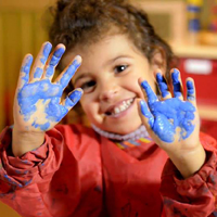 przedszkolak z pomalowanymi farbą rękoma