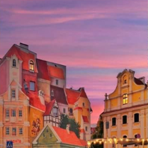Zdjęcie kamieniczek na tle zachodzącego słońca.