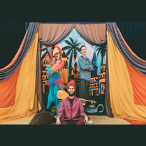 Członkowie grupy w kolorowych, orientalnych strojach w trakcie występu.