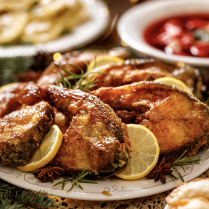 Na zdjęciu znajdują się półmiski z panierowanym karpiem, pierogami oraz barszczem z uszkami.