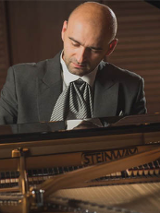 Wojciech Waleczek gra na fortepianie.