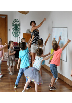 Grupa dzieci i animatorka w bawialni