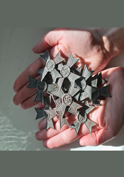 Dłonie trzymające nazistowskie odznaczenia - fragment wykopalisk