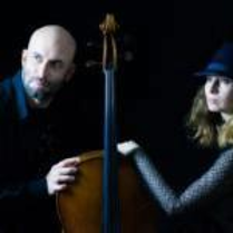 Na zdjęciu na czarnym tle dwie postaci opierające się dłońmi o kontrabas.