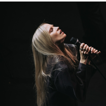 Na zdjęciu artystka z mikrofonem.