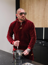 Na zdjęciu mężczyzna w okularach i amarantowej bluzie.