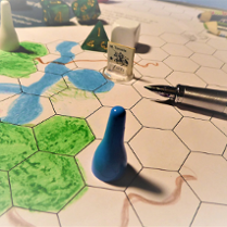 Gra planszowa, na niej długopis, pionek, kostka.