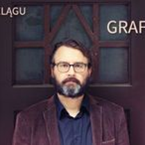 Na zdjęciu mężczyzna z brodą na tle drzwi.