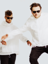 Na zdjęciu dwóch mężczyzn w białych bluzach i czarnych spodniach.