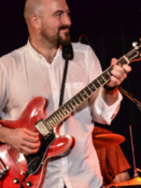 Na zdjęciu Danny Handley z gitarą.