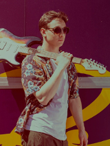 Na zdjęciu Wojtek idący z gitarą na ramieniu.