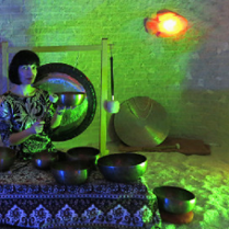 Kobieta trzymająca w ręku misę. W tle widoczny gong.