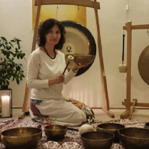 Kobieta trzymająca w ręku misę. W tle widoczny gong.