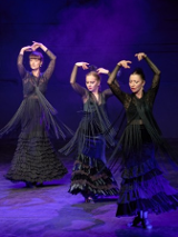Na zdjęciu trzy tancerki flamenco w czarnych sukniach.